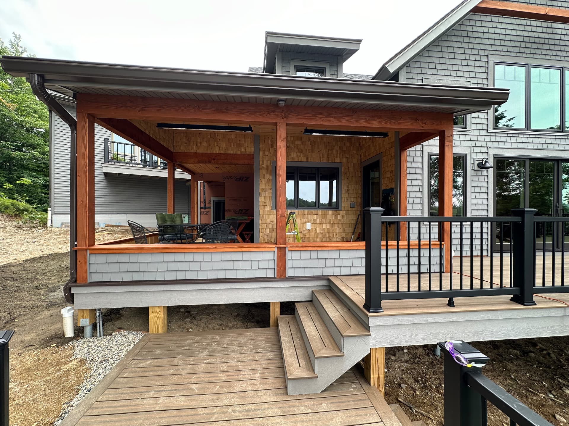 Covered porch addition with cedar shingles and composite decking