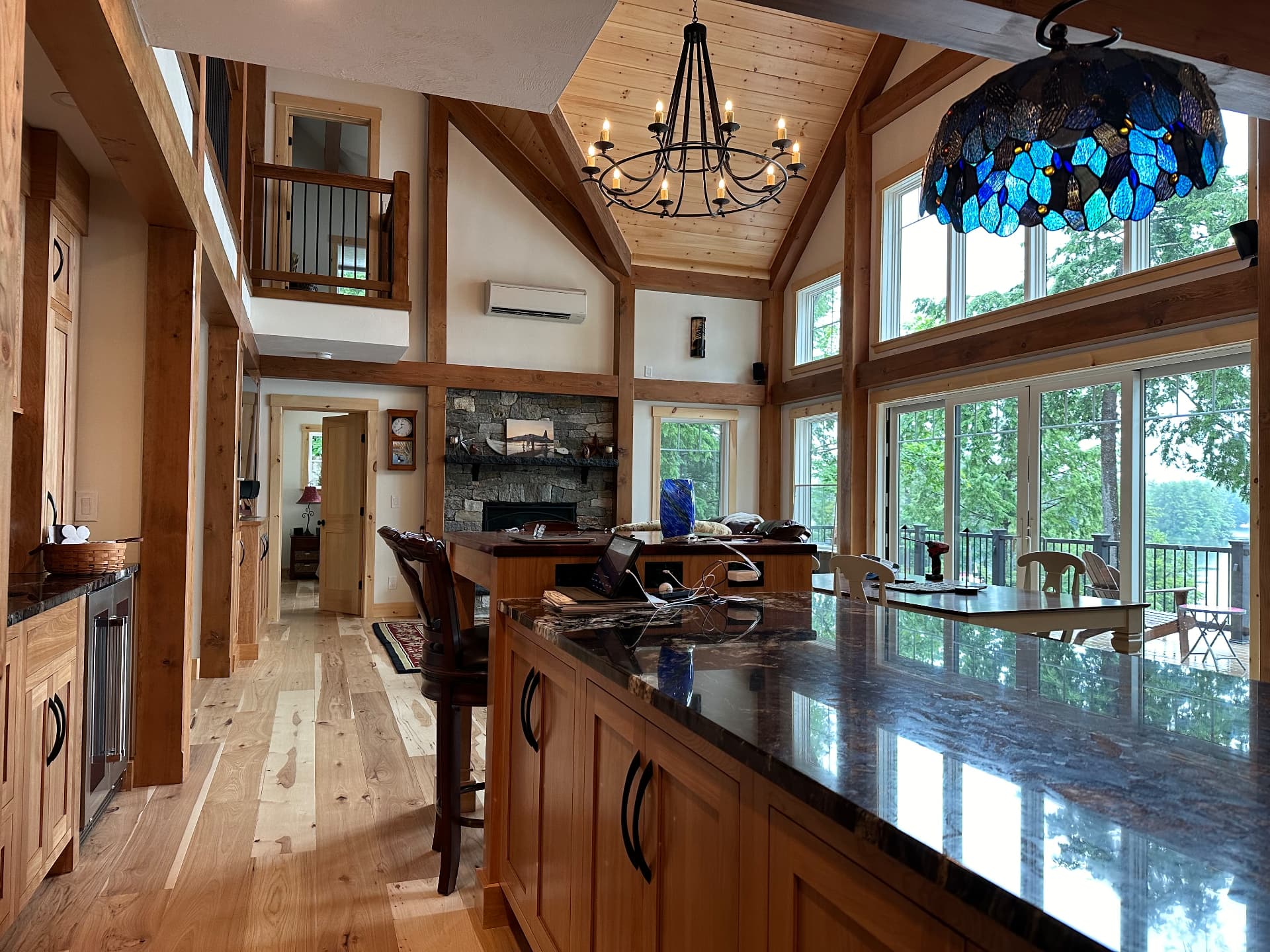 Open kitchen and great room with timber frame posts and vaulted pine ceiling