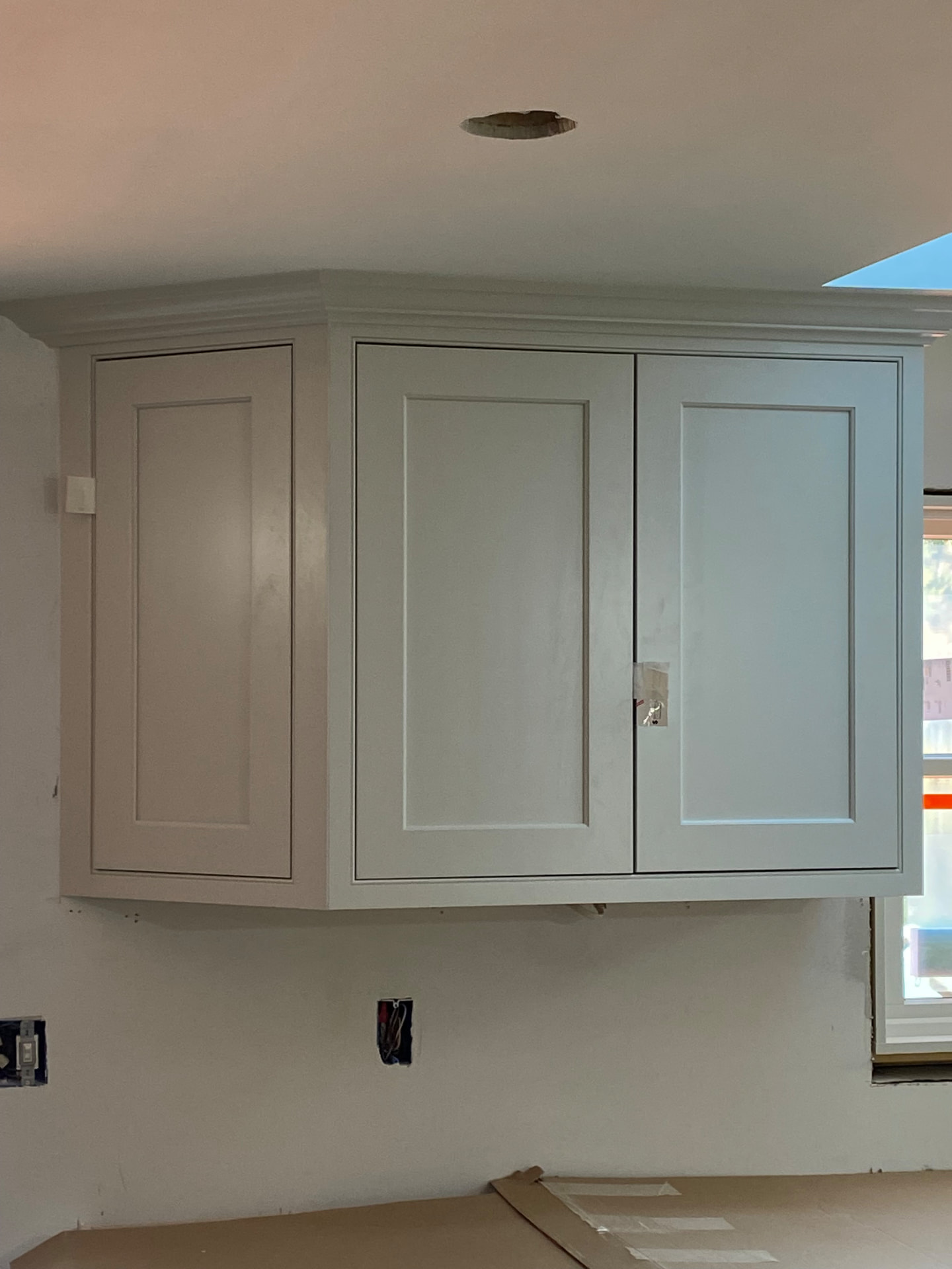 Custom upper kitchen cabinets with crown molding during installation