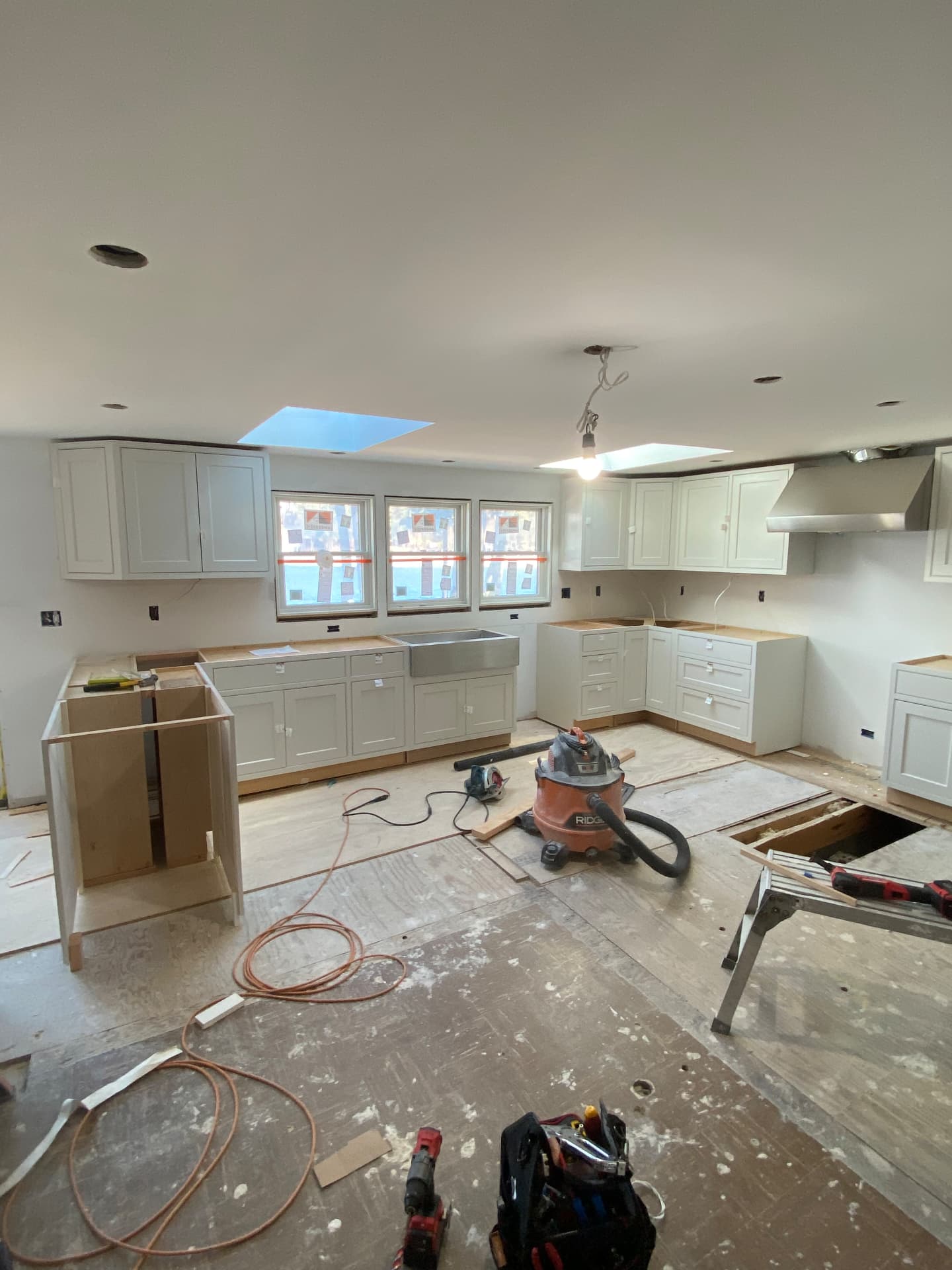 Full kitchen remodel in progress with new cabinetry and farmhouse sink