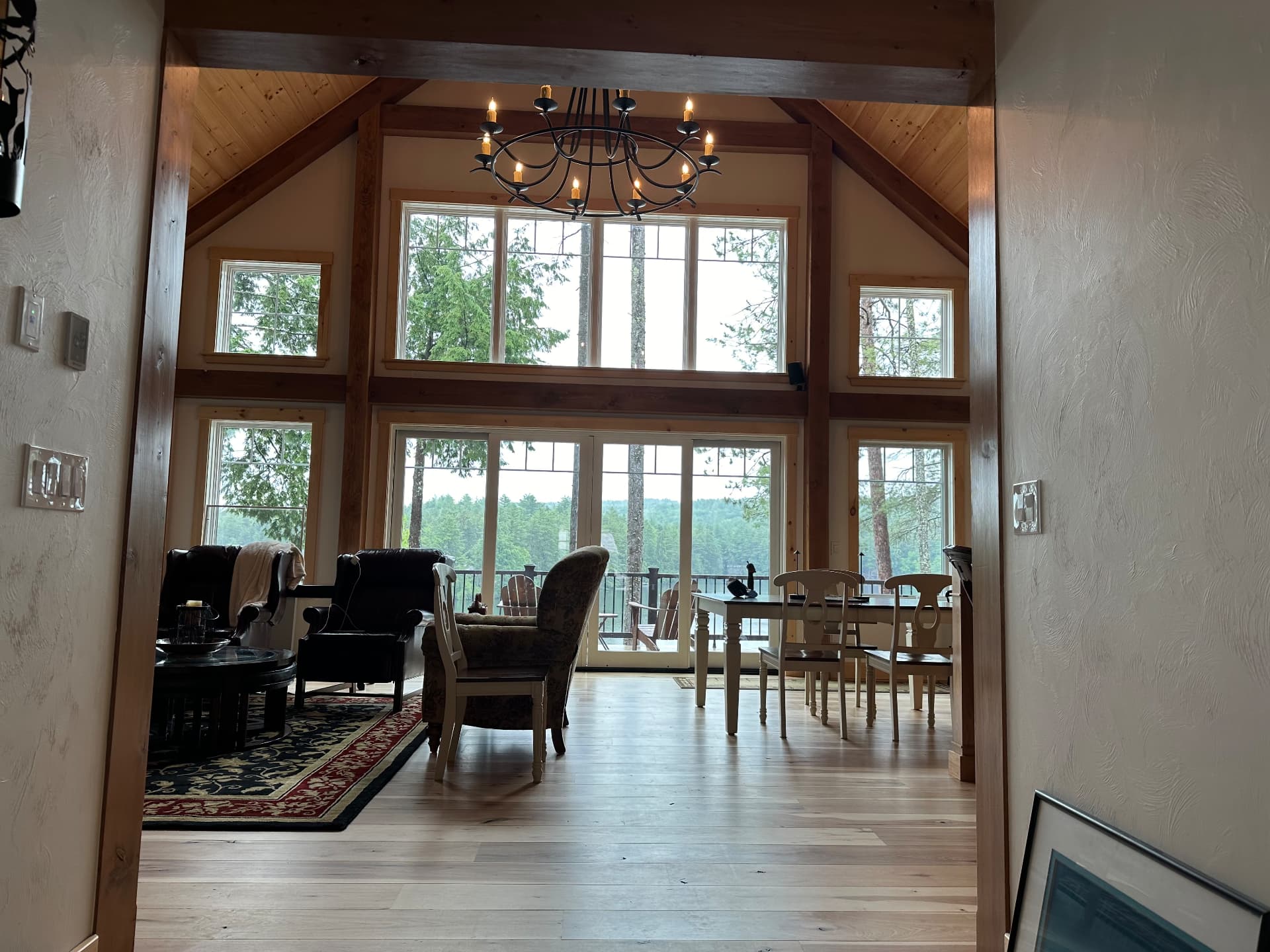 Living room with two story window wall overlooking the woods
