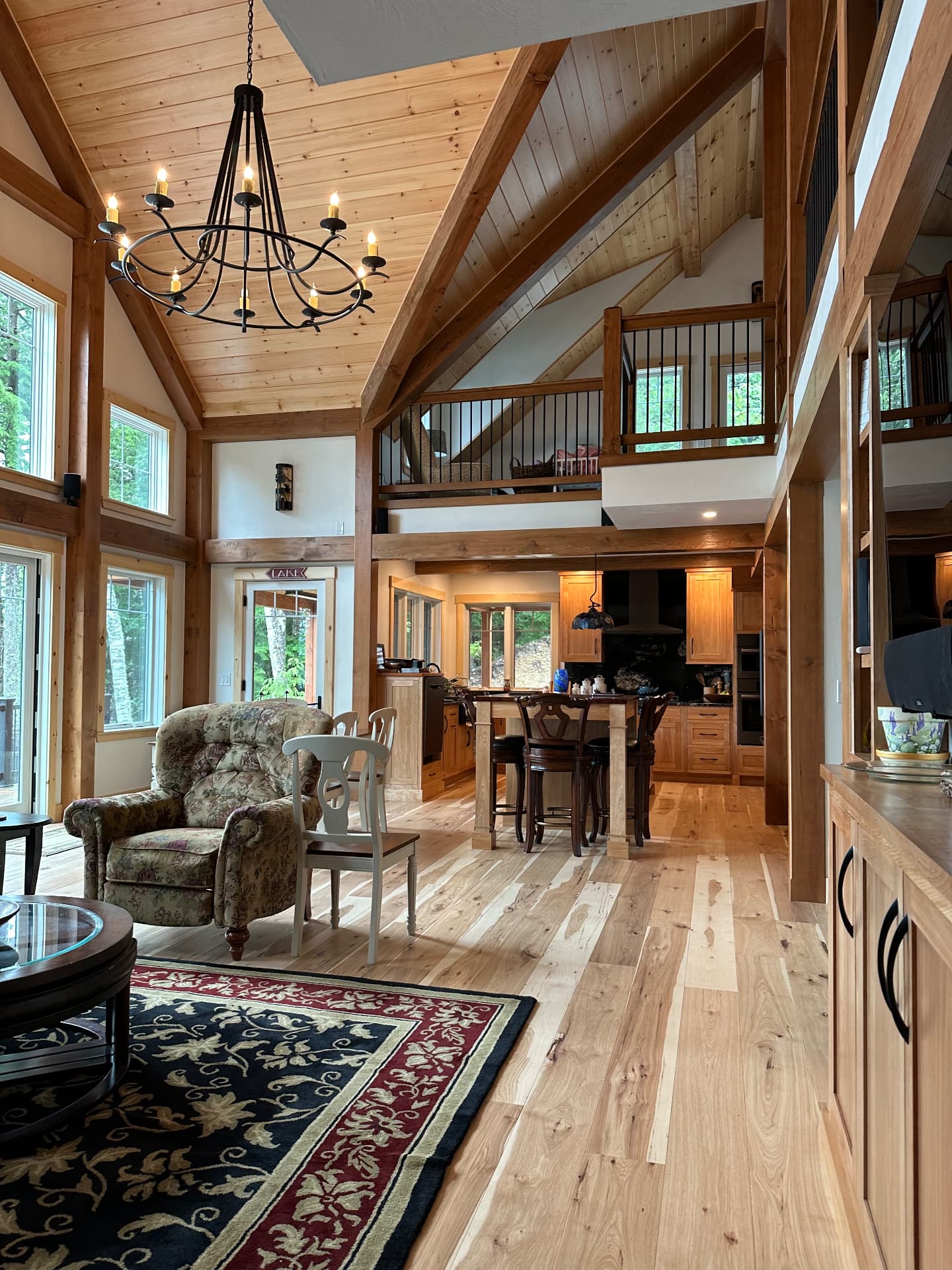 Open concept living and kitchen with hickory flooring and timber framing