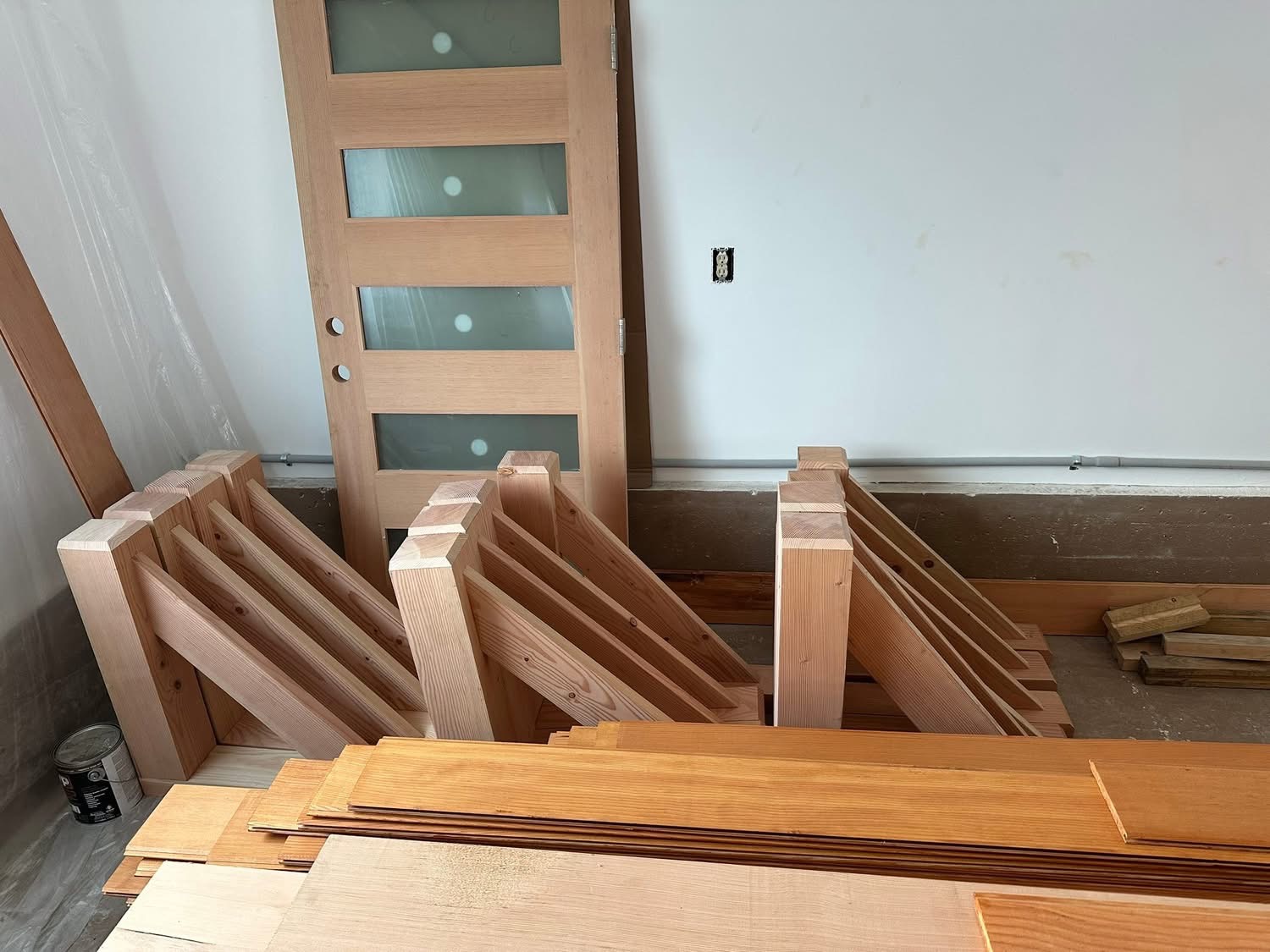 Douglas fir timber brackets and interior doors staged for install