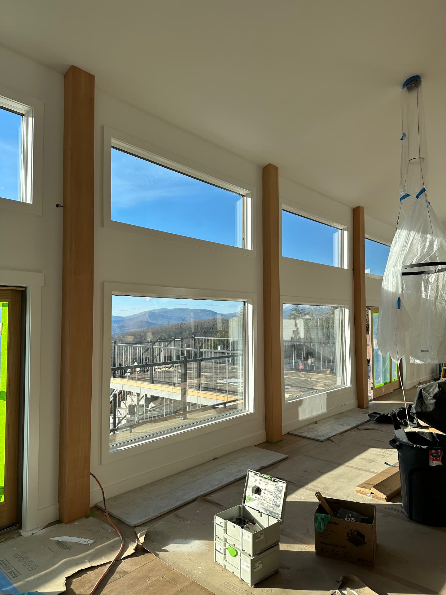 Great room window wall with mountain views during interior finish work